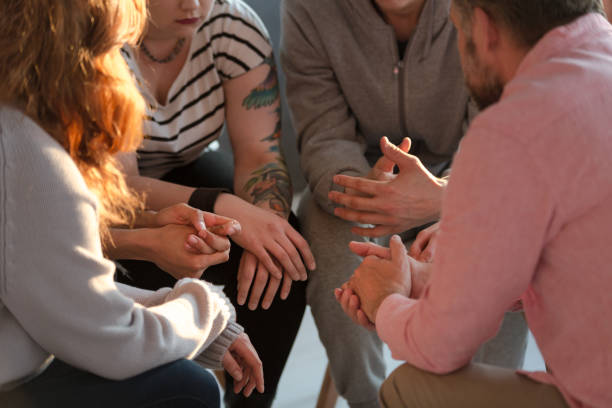 Close-up of a support group and their hands during a therapy Close-up of a support group and their hands during a therapy alcoholics anonymous photos stock pictures, royalty-free photos & images