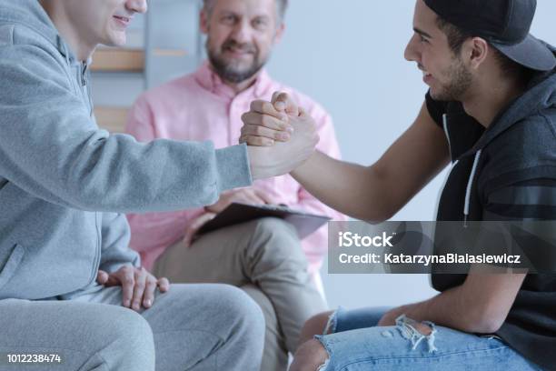 Zwei Junge Mann Hand In Hand Als Eine Geste Der Freundschaft Während Eines Treffens Der Mediation Stockfoto und mehr Bilder von Schlichtung