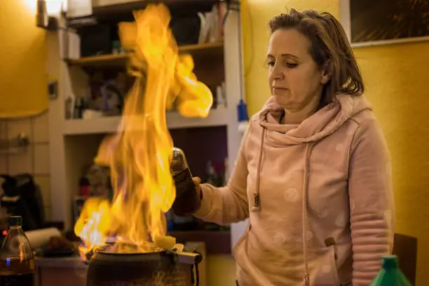 Woman prepares a fire tongs punch
(Feuerzangenbowle) ago, according to an old German recipe