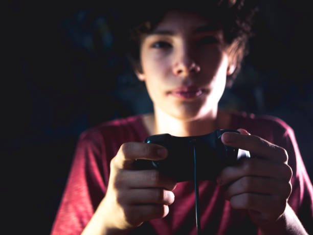 młody nastolatek w ciemnej sypialni gra konsolę gry wideo w nocy - playing video game little boys playful zdjęcia i obrazy z banku zdjęć