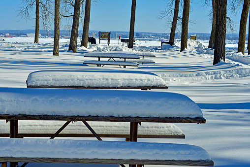 Row of picnic tables after a winter snow