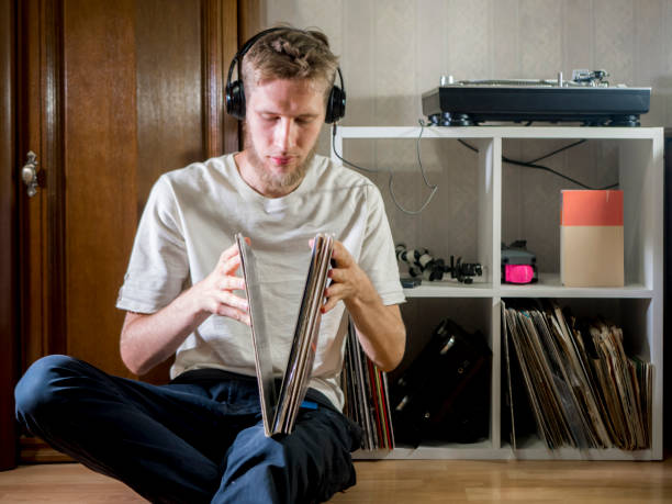 istock young man choose vinyl record to play next on turntable gramophone at home 1012250234