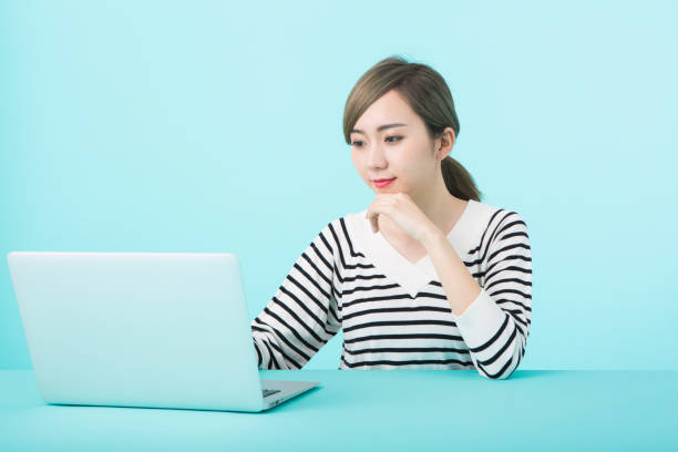 istock Young woman using laptop computer with happy face 1012259924