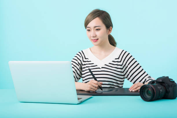 istock Young woman using laptop computer and pen tablet with happy face 1012259994