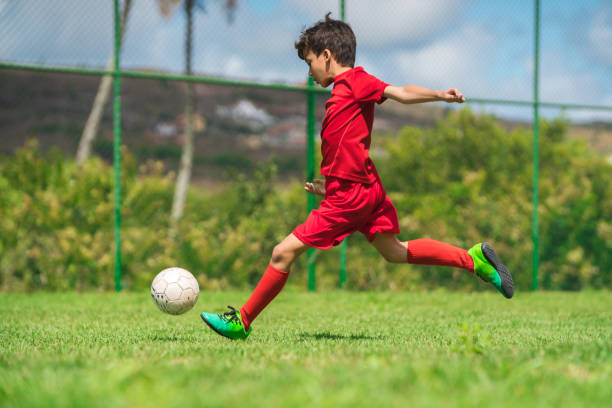 istock Boy playing soccer on court 1012260058