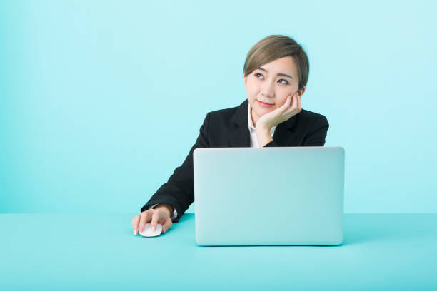 istock business woman wearing black suit using laptop computer with happy face 1012260232