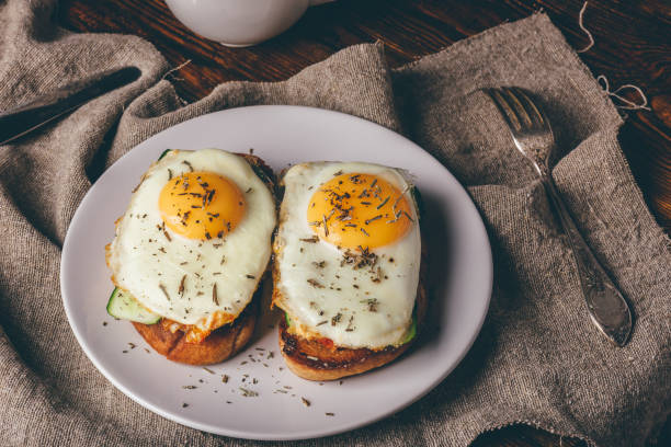 istock Italian toasts with vegetables and fried eggs on white plate and 1012272688