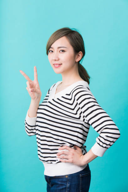 istock Young woman smiling with two fingers up 1012281398