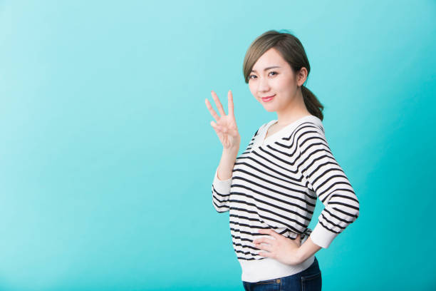 istock Young woman smiling with three fingers up 1012281458