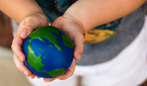 istock Holding planet earth in small hands 1012289796