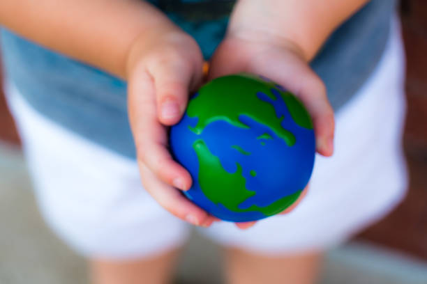 istock Holding planet earth in small hands dreaming of a future 1012289816