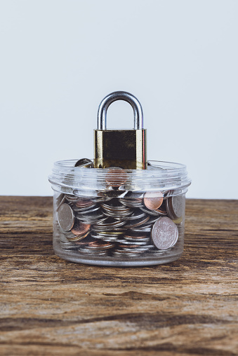 Gold and metal Padlock and full coins with jar. Save Money Concept and used for financial protection inferences or other investment messages