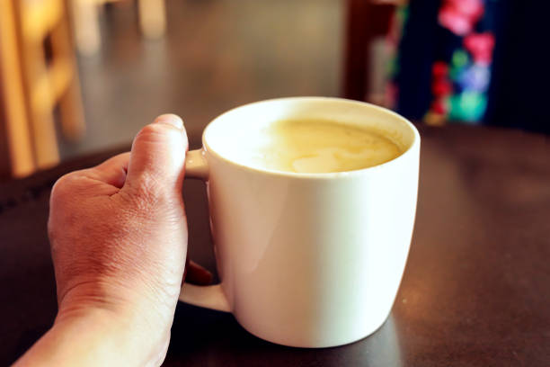 istock Cup of coffee in hand on the table 1012290316