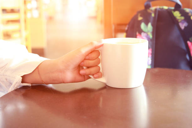 Cup of coffee in hand on the table