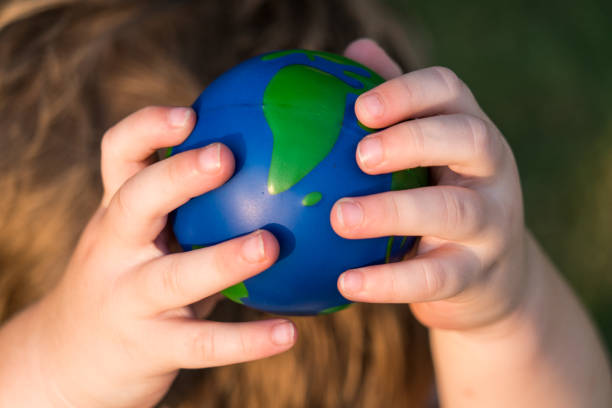 istock Holding up high planet earth sphere being held by small toddler hands 1012294126