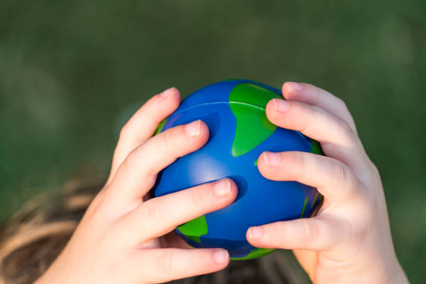 istock planet earth sphere held high in the air by small child 1012294154
