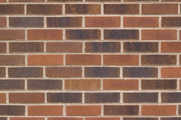 Traditional brown brick wall background with bricks of varying hues.