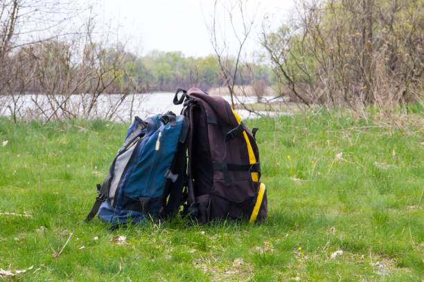 istock Two touristic backpacks on the riverbank. Hike concept 1012320920