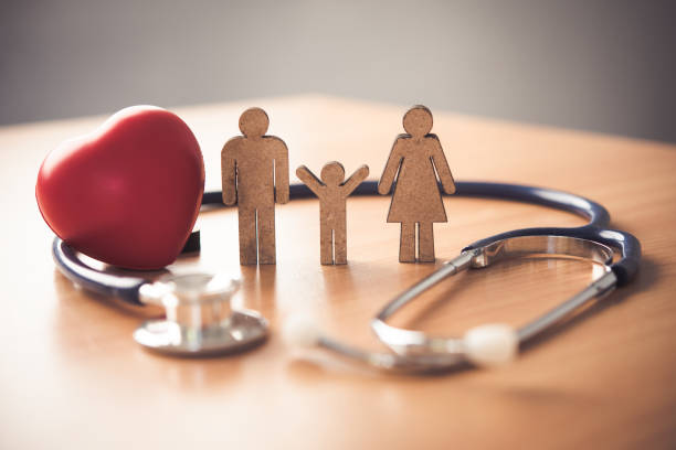 concept d’assurance médical avec la famille et le stéthoscope sur le bureau en bois - assurance maladie photos et images de collection