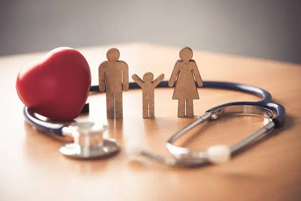 Photo of Medical Insurance Concept With Family  And Stethoscope On Wooden Desk