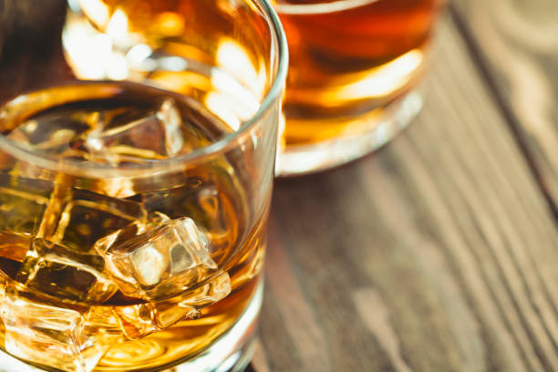 istock Whiskey with ice cubes in a glass on a wooden table. 1012329090