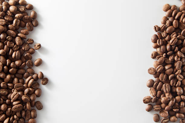 istock roasted coffee beans poured from clear glass on white background 1012341876