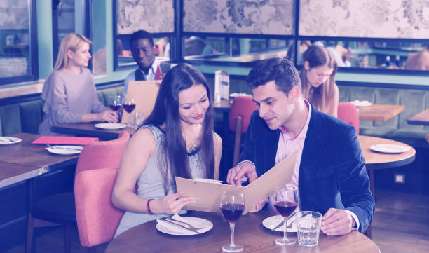istock Romantic couple choosing dishes from restaurant menu 1012354486