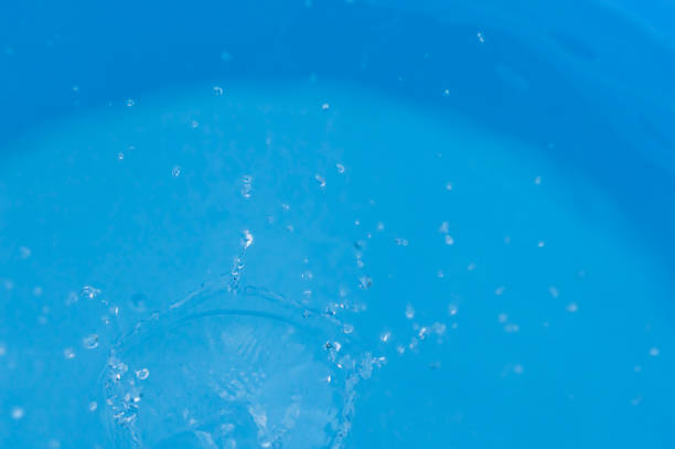 istock splashing water on a blue background, motion of water 1012356716