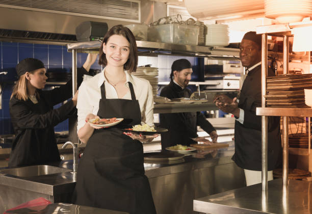 istock Waitress holding meals in restaurant kitchen 1012357312