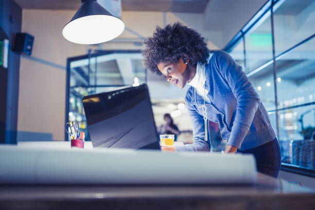 Young African-American woman architect working late in office Young African-American woman architect working on a project. She is working late afterwork african american architecture stock pictures, royalty-free photos & images