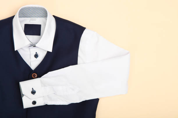 Male classic shirt and vest on beige background. Concept school uniform.