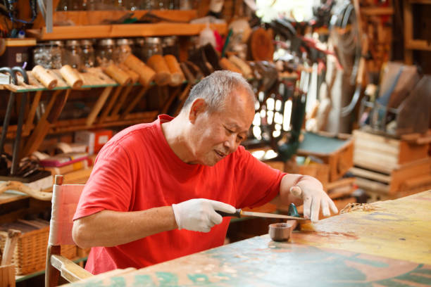 Carpinteiro sênior trabalhando com madeira - foto de acervo