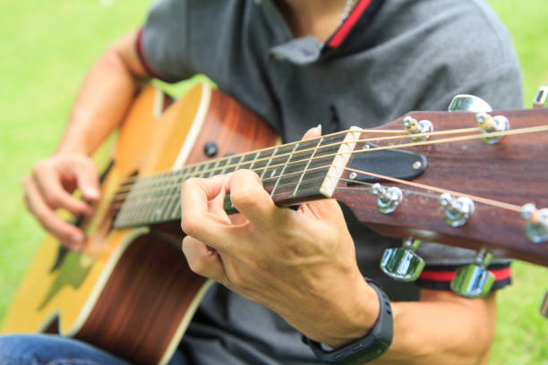 istock playing guitar in the park 1012376602