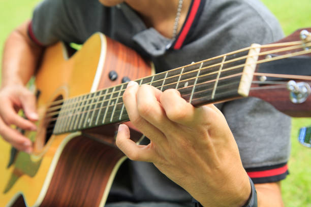 istock playing guitar in the park 1012376652