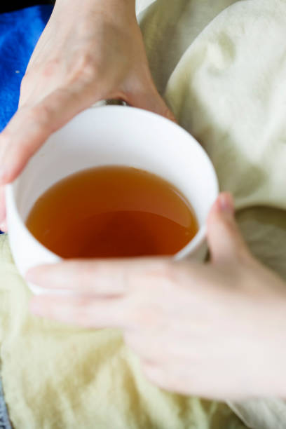 istock Girl holding a cup of tea with lemon 1012376700