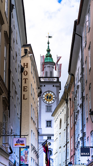 Salzburg, Austria - July 15,2017: View of famous medieval streets of Salzburg, Austria. Currently a lively shopping area. Wolfgang Amadeus Mozart was born. Clock tower of Old Town Hall