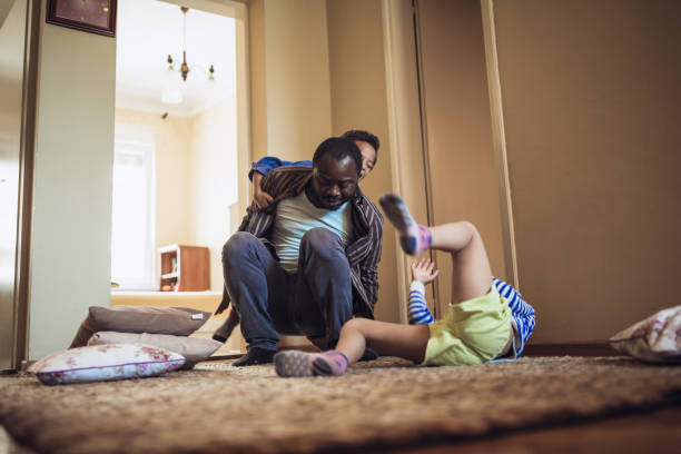 istock Kids having fun at home, playing with their father. 1012381176
