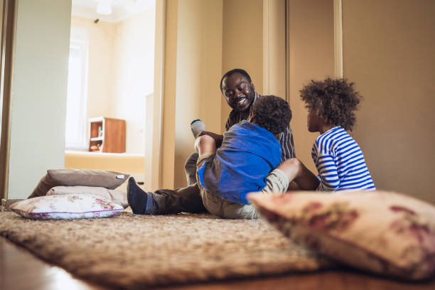istock Kids having fun at home, playing with their father. 1012381190