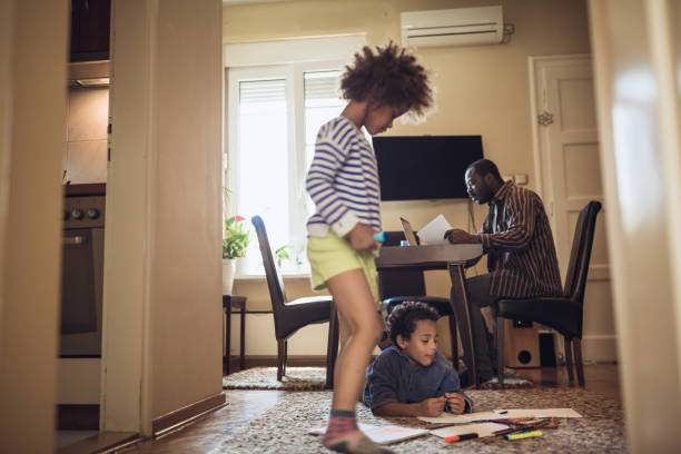 istock Kids playing while their father working at home 1012381260