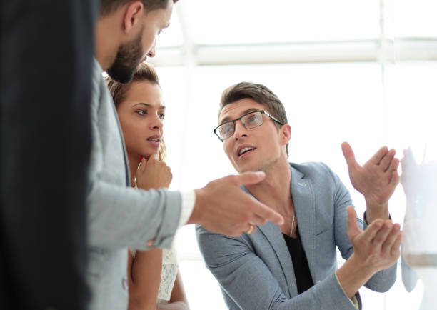 istock close up.business team talking, standing near the flipchart 1012384598
