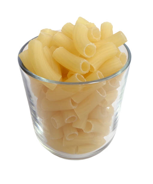 istock Transparent glass cup filled with raw pasta isolated 1012384862