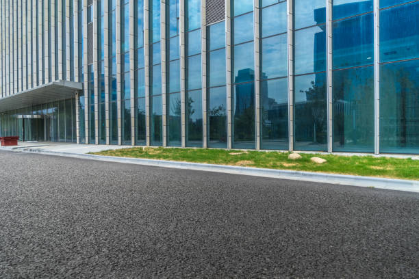 istock Modern glass building with empty asphalt road 1012389590
