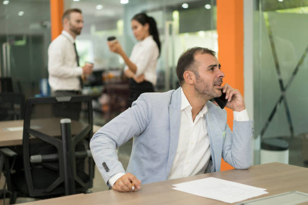 istock Focused business man talking on phone and working at desk 1012390016