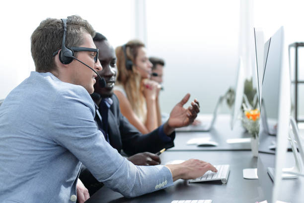 istock call center operators are talking, sitting at his Desk 1012390406