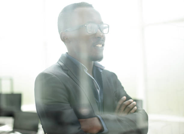 istock successful businessman looks through the office window 1012393020