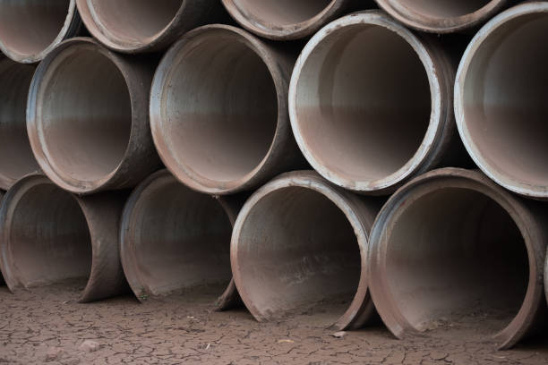 istock Concrete tubes on cracked muddy ground 1012408412
