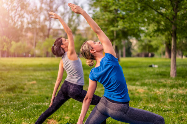 istock Two beautiful women practicing yoga in park. 1012411514