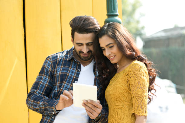 молодая пара с помощью цифрового планшета - digital tablet indian ethnicity young couple computer стоковые фото и изображения