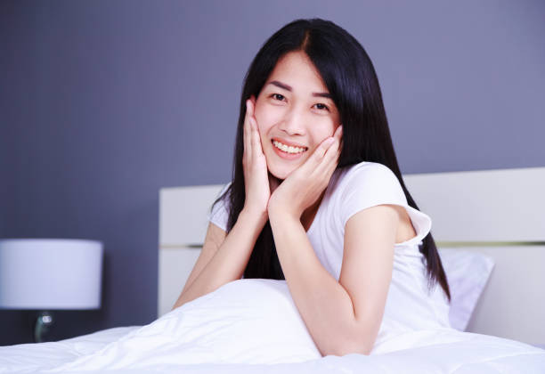 istock beautiful woman on bed in bedroom 1012412498