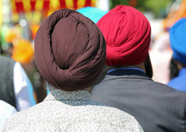 Barefoot Sikh men with turbans  during a ceremony Barefoot Sikh men with turbans during a religious ceremony turban stock pictures, royalty-free photos & images
